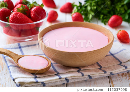 strawberry smoothie in a wooden bowl with fresh strawberry on a white table, selective focus. 115037998