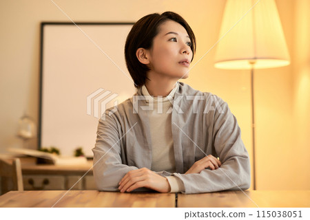室內燈光溫暖的房間裡,一位表情輕鬆的女士 室內燈光溫暖的房間裡,一位表情輕鬆的女士 115038051