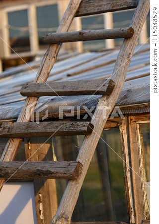An old wooden staircase tilted onto the barn. Wooden stairs in the village. An old wooden staircase tilted onto the barn. Wooden stairs in the village. 115038529