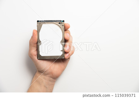 Man's hands showing a hard drive from a desktop computer close-up on a white background Man's hands showing a hard drive from a desktop computer close-up on a white background 115039371
