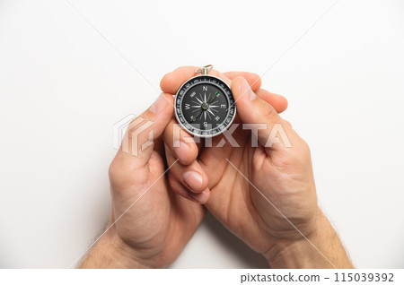 compass in hands on a white background close-up. male hands hold modern compass in retro style 115039392