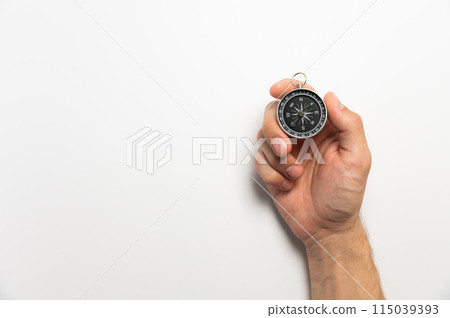Male hand holding magnetic compass on white background with copy space 115039393