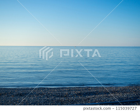Sea view in calm. Georgia beach. Pebble coast in autumn. Cold water for swimming. Not a season. blue sea. Sea view in calm. Georgia beach. Pebble coast in autumn. Cold water for swimming. Not a season. blue sea. 115039727