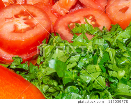 Juicy ripe tomato cut into slices. Finely chopped parsley. Snack on the table. Harvest from the garden. 115039778