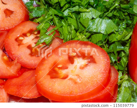Juicy ripe tomato cut into slices. Finely chopped parsley. Snack on the table. Harvest from the garden. 115039779