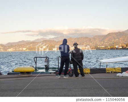 People on the pier by the sea. At the seaport. Hobbies and recreation. Fishing people. 115040056