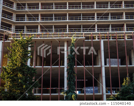 Construction of a modern high house. Building frame. Gray concrete structure. Unfinished house. 115040140