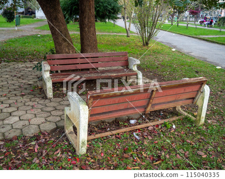 Benches on the street. Urban environment. Old benches made of wood and stone. 115040335