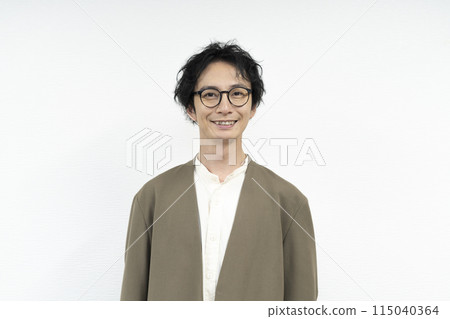 A man in his 30s wearing glasses looking at the camera 115040364
