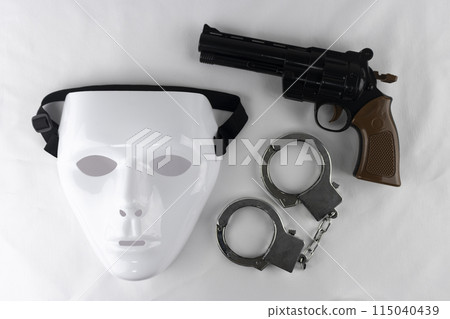 White mask, toy gun and handcuffs 115040439