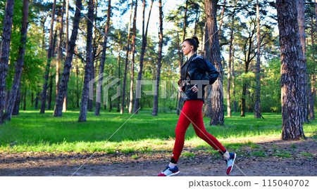 A young woman on a jog in the park. Jogging in nature. 115040702