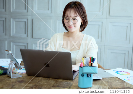 Female designer working at a computer at home 115041355