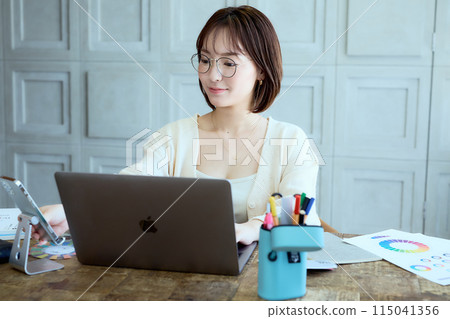 Female designer working at a computer at home 115041356