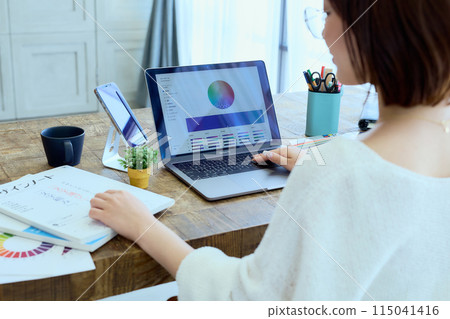 Female designer working at a computer at home Female designer working at a computer at home 115041416