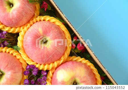 beautiful pink apple in the box on blue background beautiful pink apple in the box on blue background 115043552