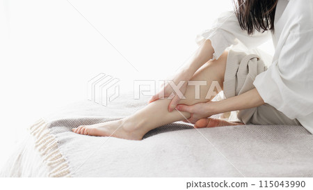 Woman massaging swollen legs Woman massaging swollen legs 115043990