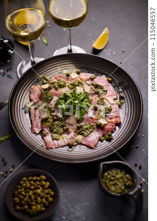 tuna carpaccio - slices of fresh raw tuna fillet on black ceramic plate tuna carpaccio - slices of fresh raw tuna fillet on black ceramic plate 115046557