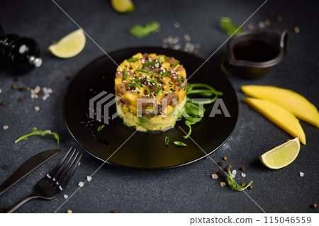 Traditional tuna and mango tartare on black ceramic plate Traditional tuna and mango tartare on black ceramic plate 115046559