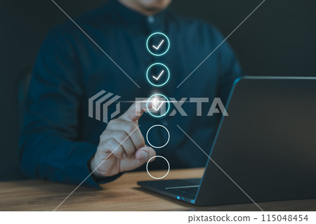 Concept of compliance to regulations product, Service, Quality control, Inspection, Standardization, certification. Businessman use a laptop computer to tick correct sign mark in checkbox. 115048454