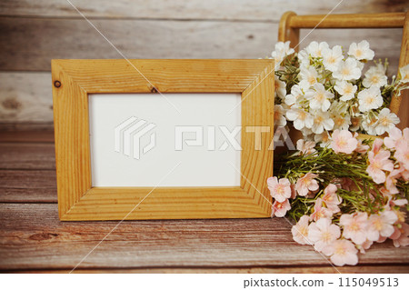 Empty Photo frame mock up with flower bouquet decoration on wooden background Empty Photo frame mock up with flower bouquet decoration on wooden background 115049513