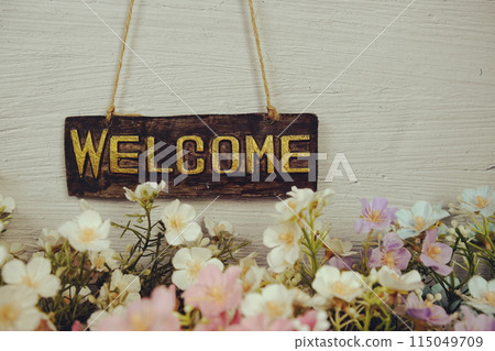 Welcome sign Hanging on grunge cement wall background Welcome sign Hanging on grunge cement wall background 115049709