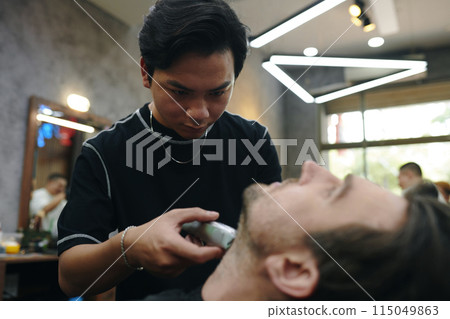 Barber Trimming Beard 115049863