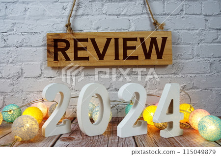Review 2024 letters with LED cotton balls decoration on wooden background 115049879