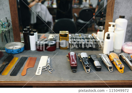 Various combs and hair clippers on table in barbershop Various combs and hair clippers on table in barbershop 115049972