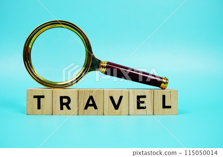 Travel with wooden blocks alphabet letters and Magnifying glass on blue background 115050014