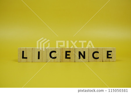 Licence with wooden blocks alphabet letters on yellow background Licence with wooden blocks alphabet letters on yellow background 115050381