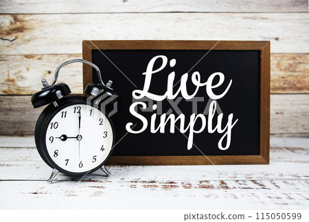 Live Simply Inspirational quote written on chalkboard with alarm clock 115050599