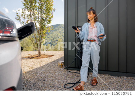 Woman plugging a charger into electric vehicle Woman plugging a charger into electric vehicle 115050791