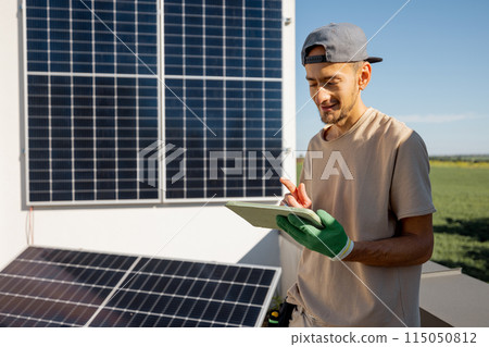 Technician with a digital tablet on a rooftop with solar power station 115050812