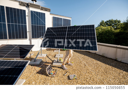 Man installing solar panels on a rooftop Man installing solar panels on a rooftop 115050855