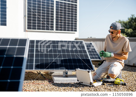 Man installing solar panels on the roof of his house 115050896