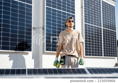 Man on a rooftop with solar panels Man on a rooftop with solar panels 115050908