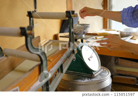 A woman measuring buckwheat flour during a handmade soba noodle experience 115051597