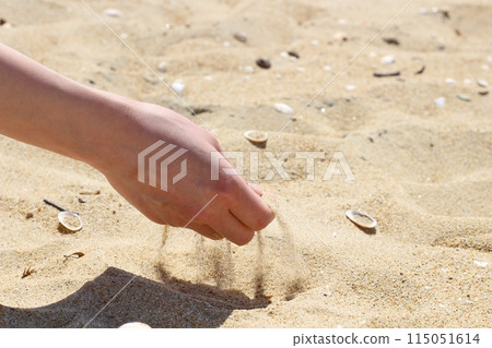 Hands holding sand on the beach, sand falling from hands Hands holding sand on the beach, sand falling from hands 115051614