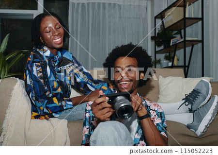 Couple Checking Photos on Camera Screen Couple Checking Photos on Camera Screen 115052223