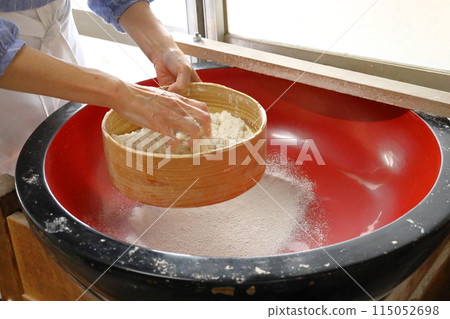 一位女士在體驗手工蕎麥麵時篩選蕎麥粉 一位女士在體驗手工蕎麥麵時篩選蕎麥粉 115052698
