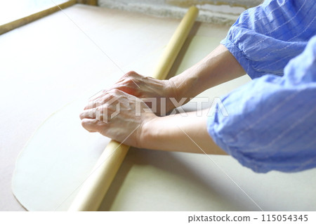 一位女士在體驗手工蕎麥麵時擀蕎麥粉 115054345