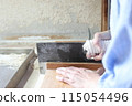 A woman cutting buckwheat flour for a handmade soba noodle experience 115054496