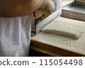 A man cutting buckwheat flour for a handmade soba noodle experience 115054498