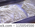 A woman cutting buckwheat flour for a handmade soba noodle experience 115054500