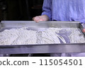 A woman cutting buckwheat flour for a handmade soba noodle experience 115054501