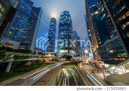 Skyscraper buildings and traffic on road with blurred cars light trails at night, Hong Kong, China 115055063