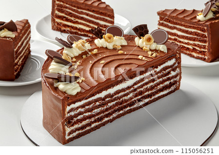 Sliced layered honey chocolate cake with whipped sour cream 115056251
