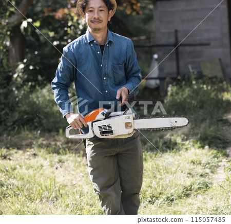 Man carrying a chainsaw Man carrying a chainsaw 115057485