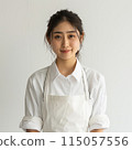 A young woman in an apron 115057556