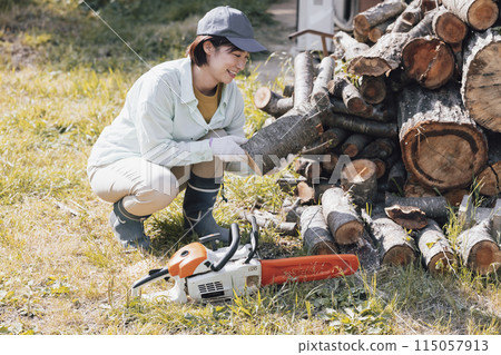 Woman cutting firewood 115057913